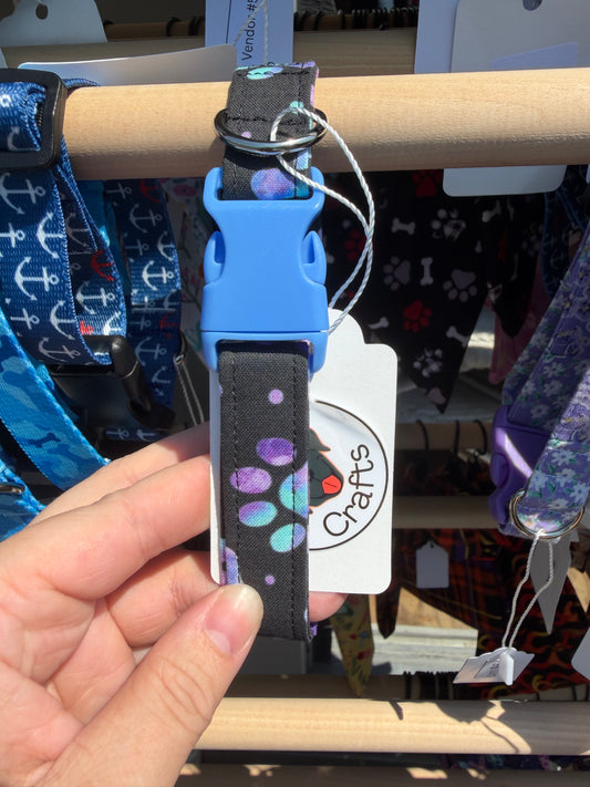 Purple and teal paw prints on Black Dog Collar